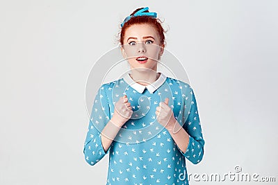 Yes! Isolated studio shot on gray background of happy successful young redhead girl winner, feeling lucky Stock Photo