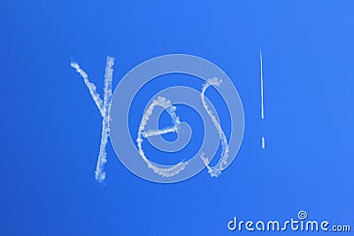 Yes skywriting in clear blue sky Stock Photo