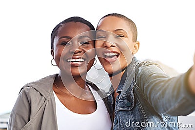 The yin to my yang. Portrait of two young women smiling and posing while taking a selfie in the city. Stock Photo