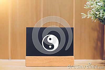 Yin and yang on a blackboard and wooden background Stock Photo