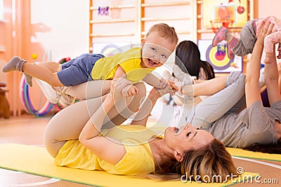 Yoga for babies. Child-friendly fitness for women with toddlers. Lifestyle concept of parent activity with kids. Stock Photo