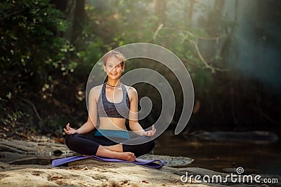 YOGA Backside young woman practicing yoga and relaxing in fores Stock Photo