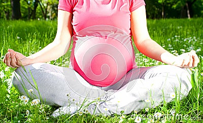 Yoga, Beautiful pregnant woman relaxing in the park. Stock Photo