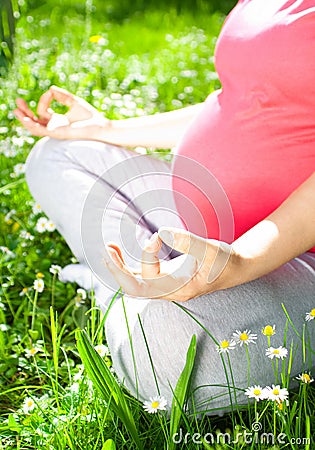 Yoga, Beautiful pregnant woman relaxing in the park. Stock Photo