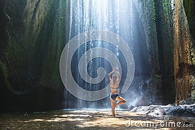 Yoga, beautiful woman practices in waterfall, body and mind harmony Stock Photo