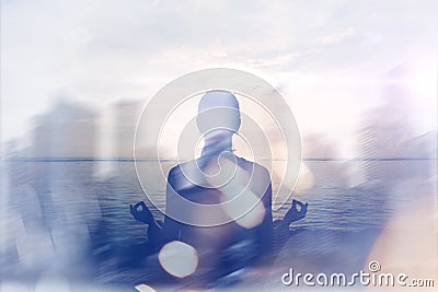 Yoga concept. Double exposure. Woman doing yoga practice on the beach and silhouette of modern city Stock Photo