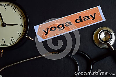 Yoga Day on the print paper with Healthcare Concept Inspiration. alarm clock, Black stethoscope. Stock Photo