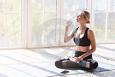 Yoga girl having break while morning exercising, drinking water Stock Photo