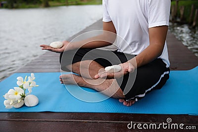 Yoga hand meditation exercise near pond Stock Photo