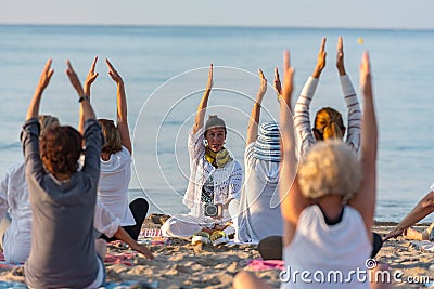 Yoga instructor leading a group session at sunset on the beach in Altafulla, Tarragona, Spain Editorial Stock Photo