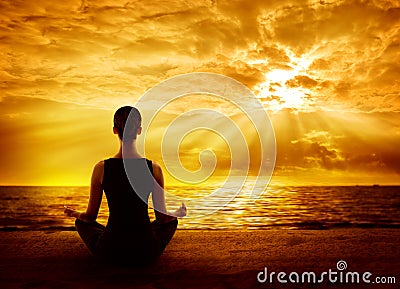 Yoga Meditating Sunrise, Woman Mindfulness Meditation on Beach Stock Photo
