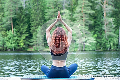 Yoga meditation in lotus pose by Young yogi girl on the pier of a beautiful lake. Concept of healthy life and natural balance Stock Photo