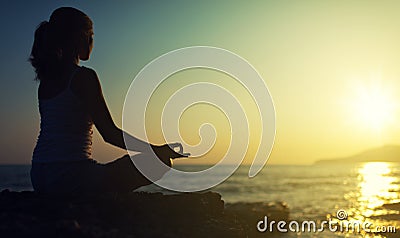 Yoga outdoors. silhouette of a woman sitting in a lotus position Stock Photo