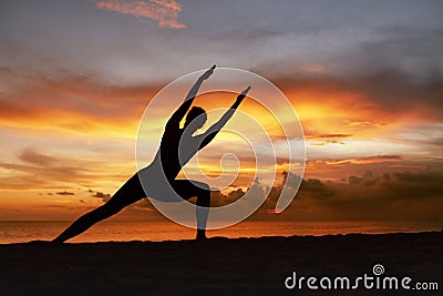 Yoga Poses. Woman Practicing Side Angle Asana On Ocean Beach. Female Silhouette Standing In Parivrtta Parsvakonasana. Stock Photo