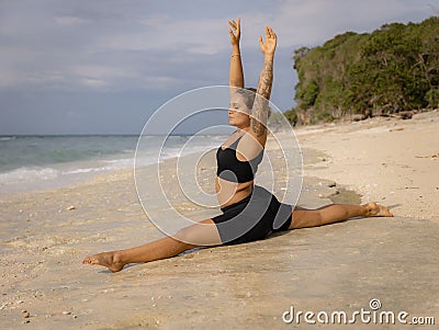 Yoga practice. Attractive Caucasian woman practicing Hanumanasana, Monkey Pose or Front Split. Arms rasied up. Hamstrings Stock Photo