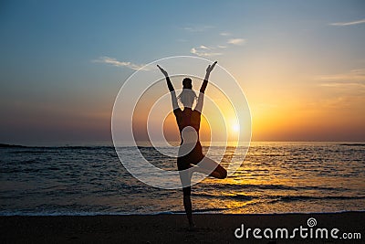 Yoga silhouette meditation fitness woman on the ocean. Stock Photo