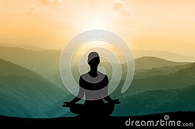 Yoga silhouette on the mountain in sunrays Stock Photo