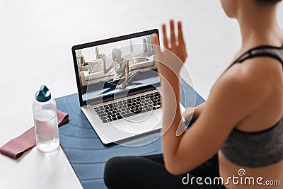 Yoga teacher conducting a virtual class on laptop Stock Photo