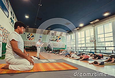 Yoga teacher explaining asanaa for active people in sport studio, training class Editorial Stock Photo