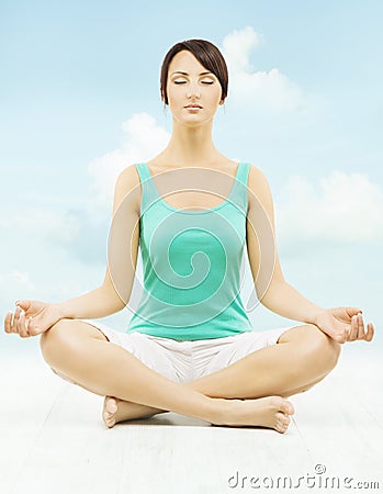 Yoga woman meditate sitting in lotus pose over sky Stock Photo