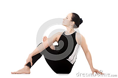 Yogi athlete girl in yoga asana parivritta Eka Pada Agnistambhasana Stock Photo