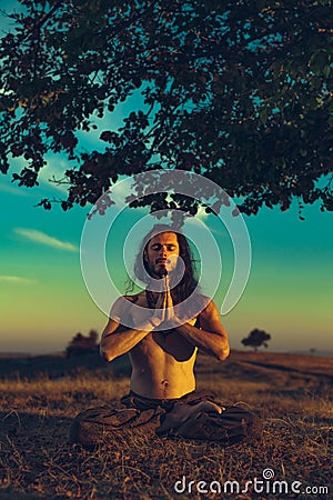 Yogi man meditating at sunset on the hills. Lifestyle relaxation emotional concept spirituality harmony with nature Stock Photo