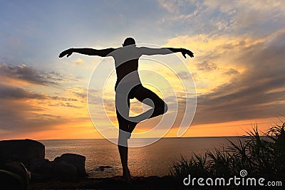 Yogi meditating at sunset Stock Photo
