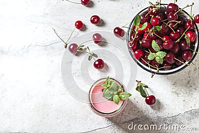 Yogurt with cherry, mint and and fresg berries on a light concrete background. Summer healthy dessert with berries Stock Photo