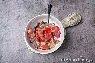 Yogurt and fruit in a bowl. Greek yogurt with fruit and nuts, healthy diet friendly dessert. Stock Photo