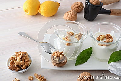 Yogurt with walnuts on white wooden table elevated view Stock Photo