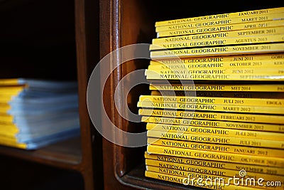 National Geographic magazines pile on a wooden shelf Editorial Stock Photo