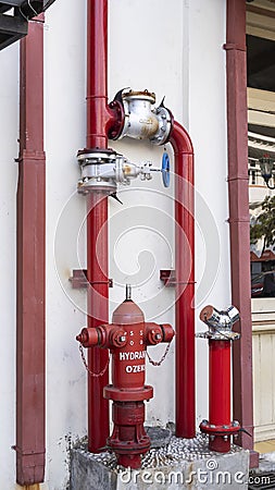 A red hydrant, permanent fire extinguishing installation that consists of a pipeline filled with pressurized water and ready to be Editorial Stock Photo