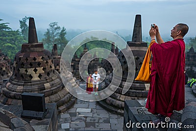 Yogyakarta, Indonesia - March 17, 2018: Monk makes photos at Borobudur temple sunrise in Yogyakarta Editorial Stock Photo
