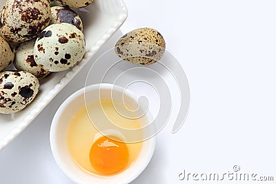 Yolk quail egg without shell and raw quail eggs in bowl on white background. Stock Photo