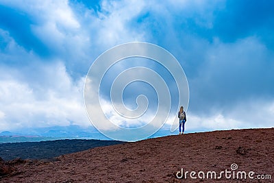 Yong woman enjoying unearthly landscape of Etna volcano, Sicily Stock Photo