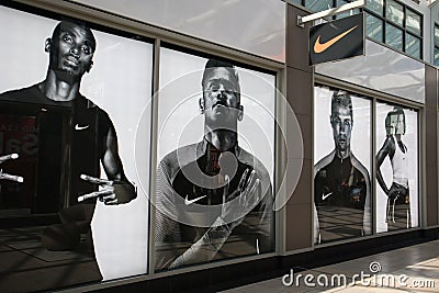 Exterior of Nike store shop showing company logo, sign, signage and branding and window display. Inside shopping centre mall Editorial Stock Photo