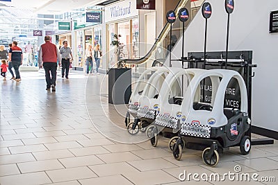 Interior view of shopping centre showing childs police buggie and customers Editorial Stock Photo