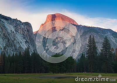 Yosemite National Park view of Half Dome from the Valley during colorful sunset with trees and rocks. California, USA Stock Photo
