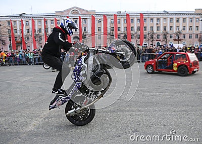 YOSHKAR-OLA, RUSSIA - MAY 5, 2018: Motoshow in the central square of the city. Tricks on a motorcycle, stuntmen, Stunt Riding Editorial Stock Photo