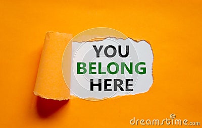 You belong here symbol. Words `You belong here` appearing behind torn orange paper. Beautiful orange background. Business, Stock Photo