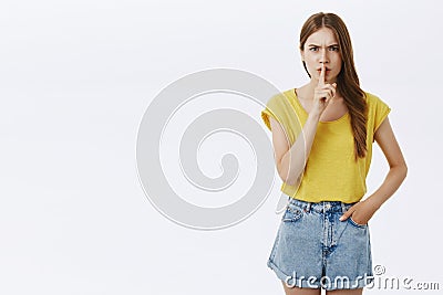 You better keep mouth shut. Portrait of serious-looking bothered intense charming tall female in yellow t-shirt frowning Stock Photo