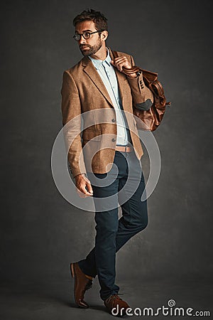 You can never be overdressed. Studio shot of a handsome young man posing against a gray background. Stock Photo