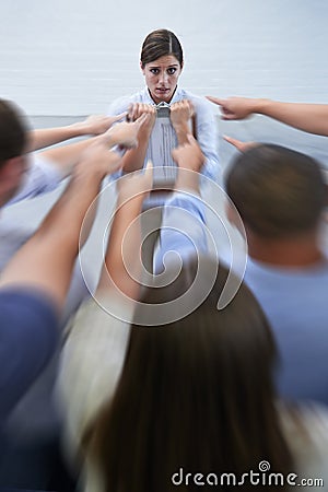 You did this. an anxious young woman facing the accusatory fingers of her coworkers. Stock Photo