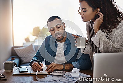 You have to save and spend wisely. a young couple planning their budget together at home. Stock Photo