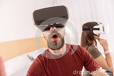 Amazed handsome man watching through VR glasses Stock Photo