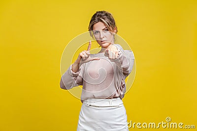 You are loser! Portrait of serious bossy woman with fair hair in casual beige blouse, isolated on yellow background Stock Photo