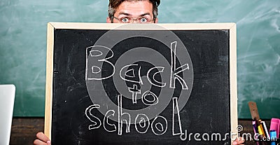 Are you ready study. Teacher or school principal welcomes inscription back to school. Teacher peeking out blackboard Stock Photo