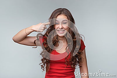 Are you stupid, out your mind. Young brunette woman asking, gesturing are you crazy, twisting for finger at his temple Stock Photo