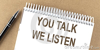 YOU TALK WE LISTEN text on a notepad with pen, business Stock Photo