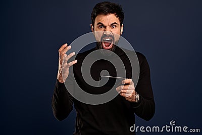 You will have problems man. Portrait of angry confused aggressive in bad mood guy shouting threatening, man holding mobile phone Stock Photo